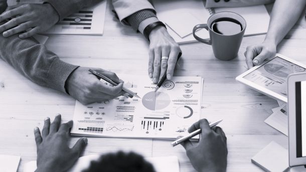 Equipo comercial analizando datos y métricas de clientes sobre la mesa